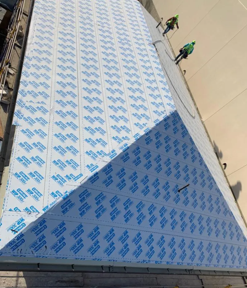 Professional roofers installing underlayment on a metal roof in Greenwood